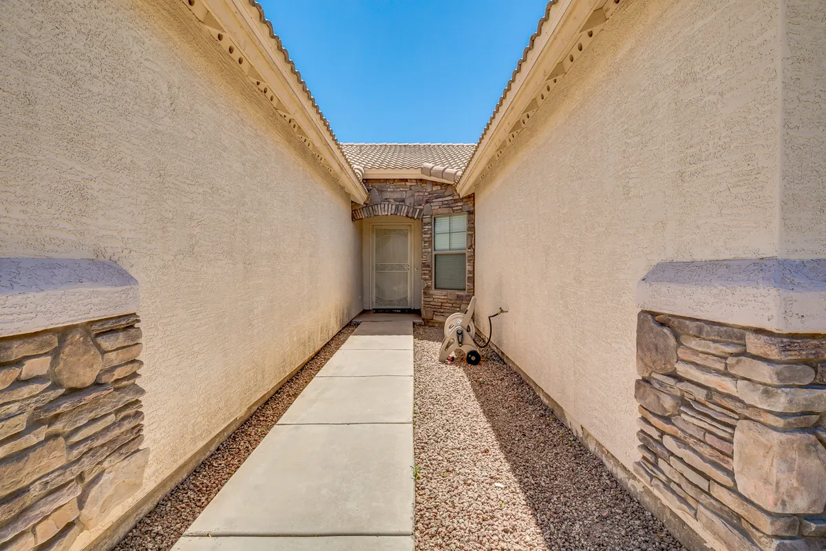 An exterior perspective showing the pathway leading to the home's front entryway, enhanced by attractive stone accents. The scene captures the anticipation and warm welcome as guests arrive at the front door.